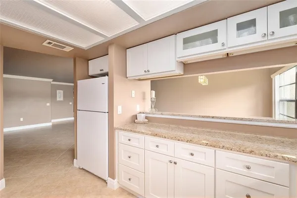 a kitchen with granite countertop cabinets and refrigerator