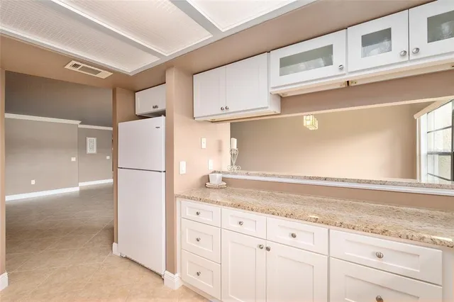 a kitchen with granite countertop cabinets and refrigerator