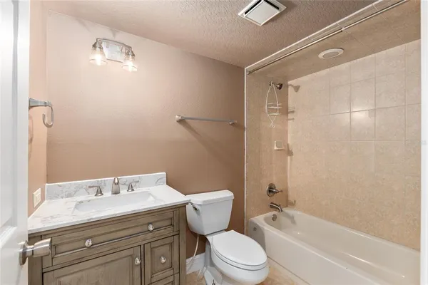 a bathroom with a granite countertop sink a toilet and shower