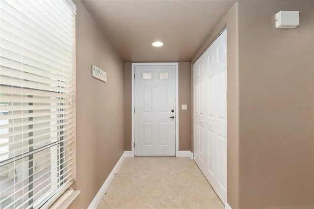 a view of a hallway with wooden floor and a bathroom