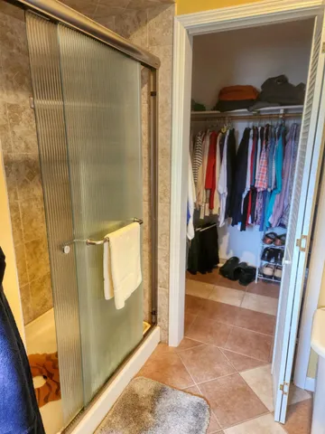 a view of walk in closet with clothes and shoes