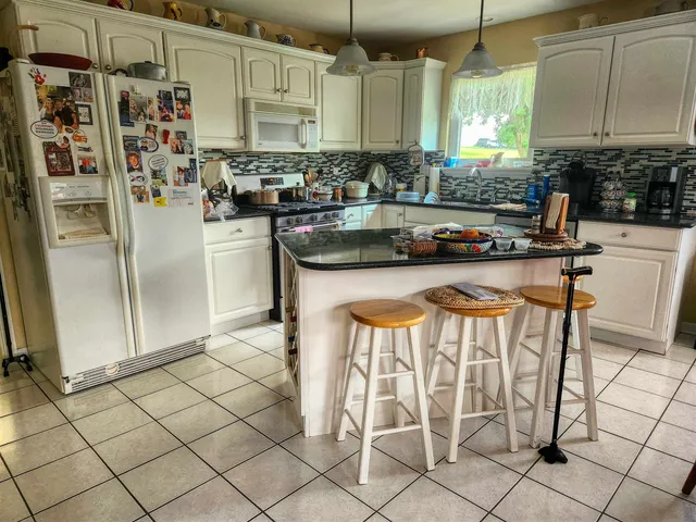 a kitchen with granite countertop a refrigerator and a stove