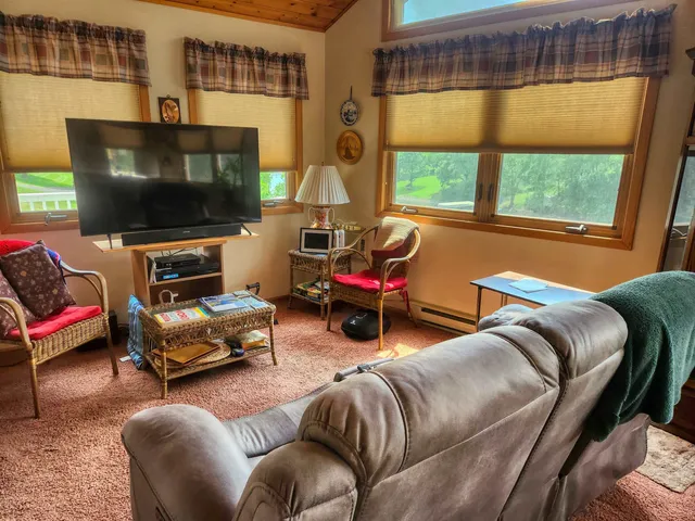 a living room with furniture a flat screen tv and a window