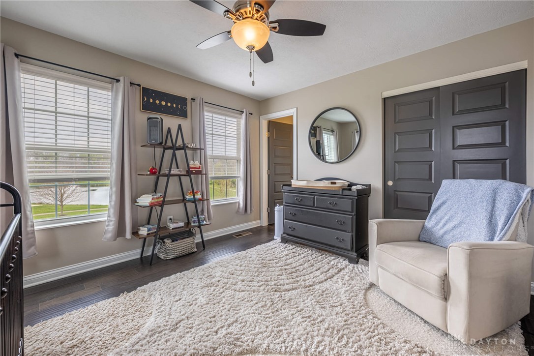 407 Brownstone Row Springboro, OH 45066 - Photo 33 of 54 This cozy bedroom features rich wood flooring, ample natural light, and a functional ceiling fan.