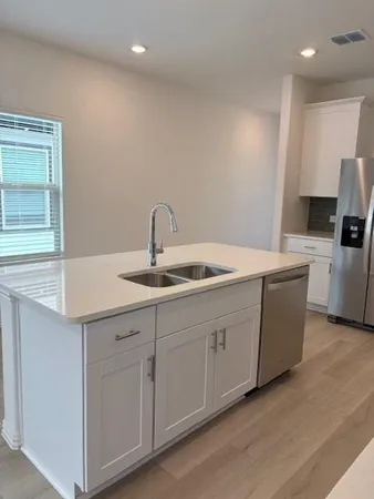 a kitchen with sink a microwave and refrigerator