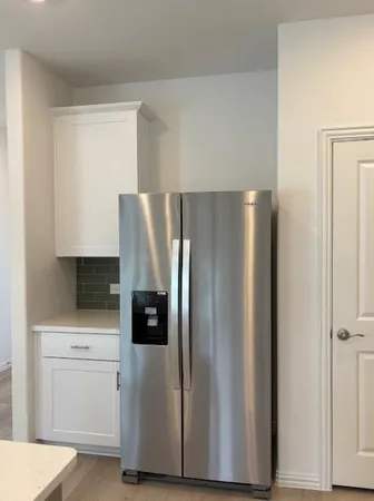 a kitchen with appliances a refrigerator and cabinets