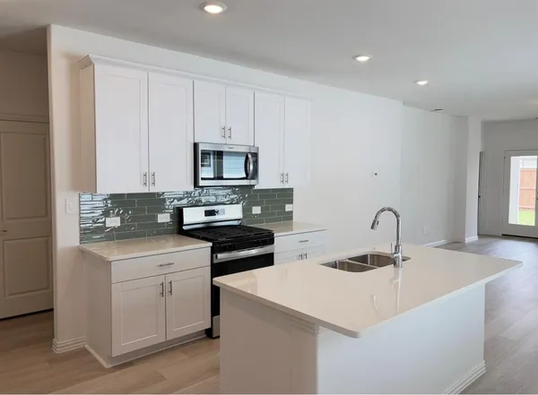 a kitchen with a sink a stove and cabinets