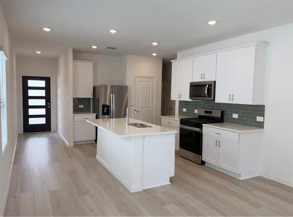 a large kitchen with stainless steel appliances lots of counter top space