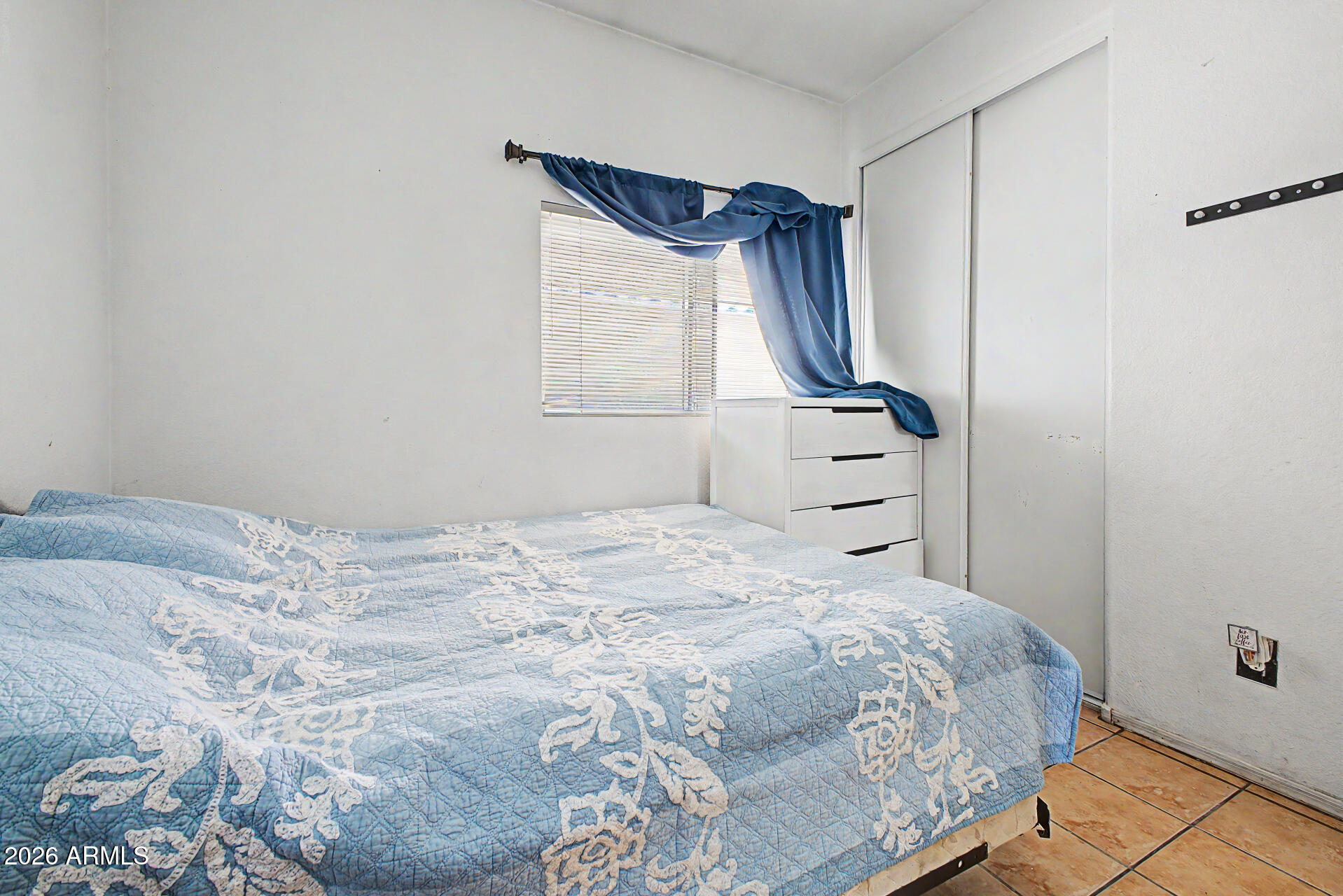 9730 West Payson Road Tolleson, AZ 85353 - Photo 21 of 57 a bedroom with a bed and a window