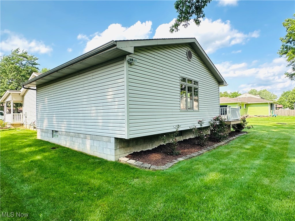 1684 Morris Street Mineral Ridge, OH 44440 - Photo 16 of 50 View of property exterior featuring a yard and ac unit
