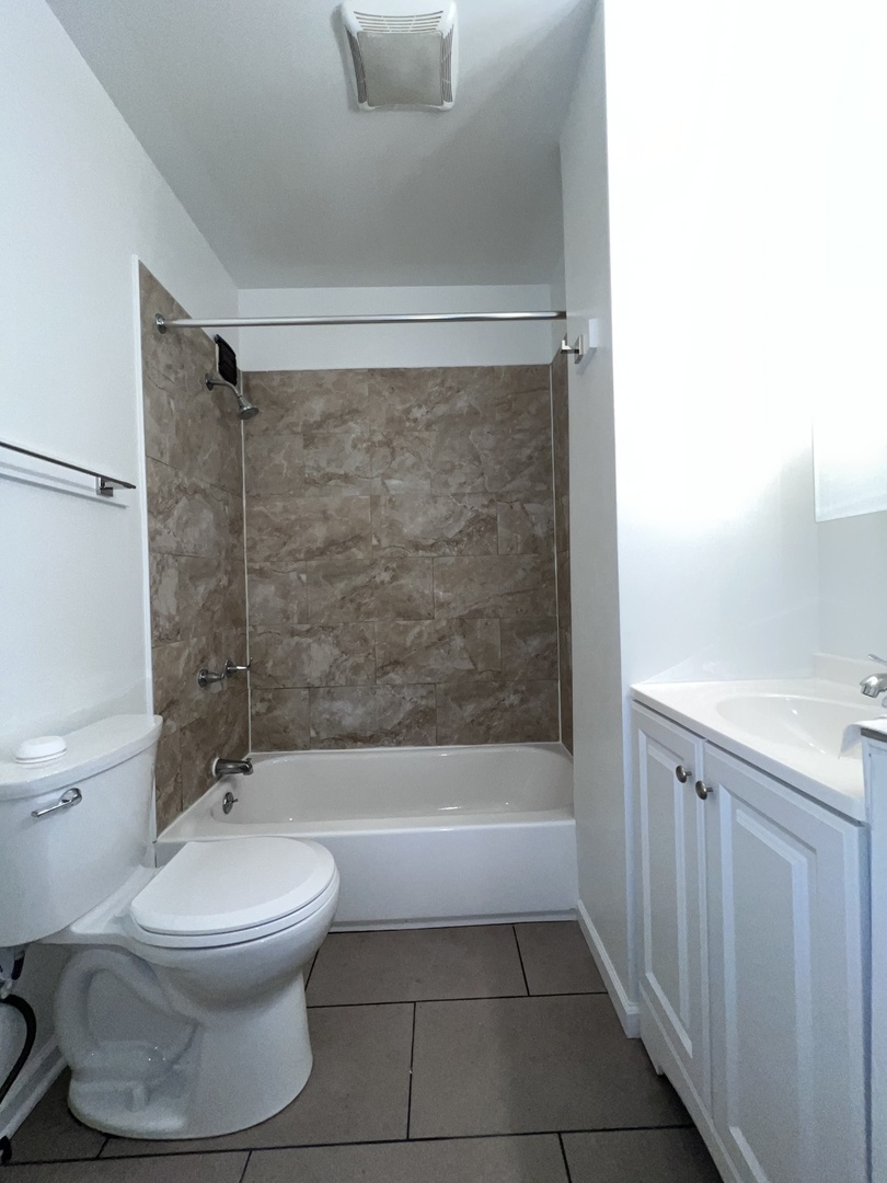 8919 South Muskegon Avenue, Unit 1F Chicago, IL 60617 - Photo 22 of 33 a bathroom with a toilet and a shower