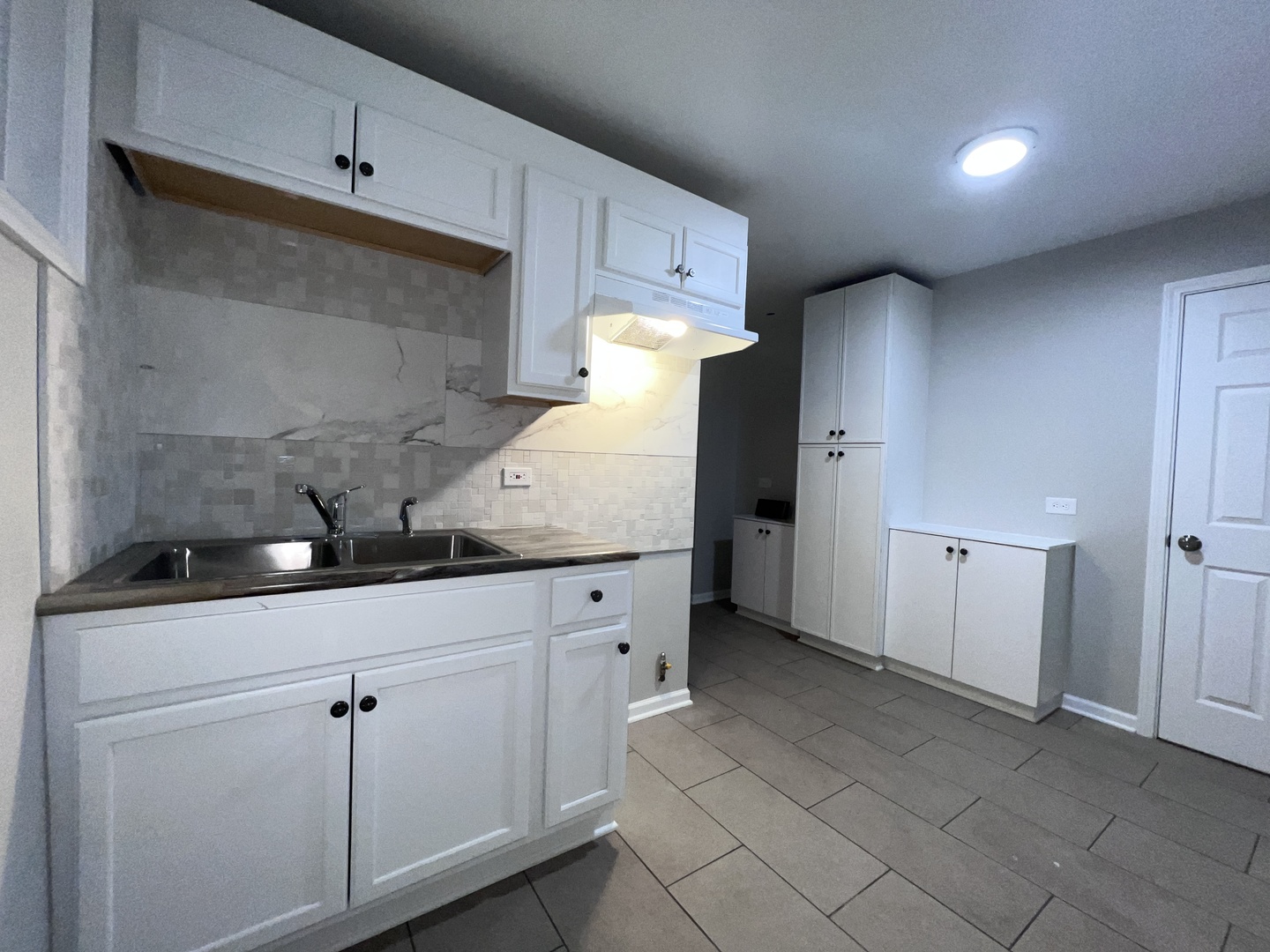 8919 South Muskegon Avenue, Unit 1F Chicago, IL 60617 - Photo 25 of 33 a kitchen with granite countertop white cabinets and white appliances