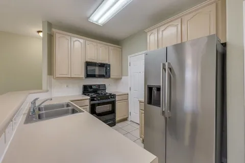 a kitchen with a refrigerator a stove top oven a sink and dishwasher