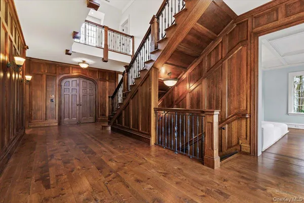 a view of a hallway with wooden floor and staircase