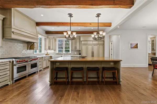 a kitchen with a dining table chairs and wooden floor