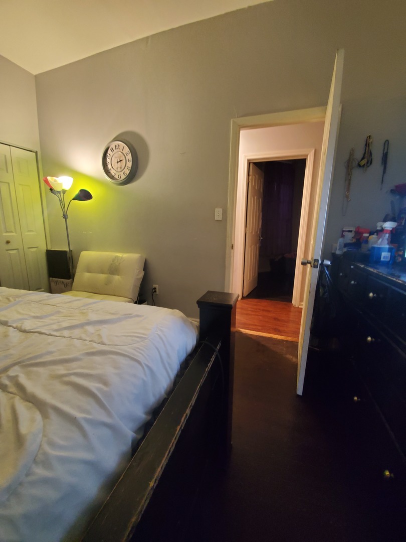 Undisclosed Address Chicago, IL 60623 - Photo 14 of 21 a bedroom with a bed and a chandelier