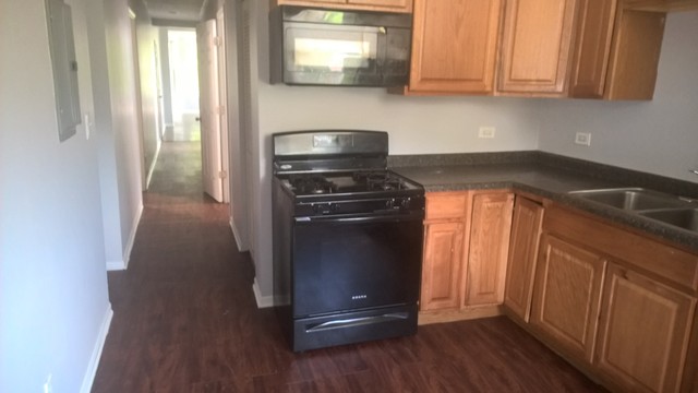 Undisclosed Address Chicago, IL 60623 - Photo 15 of 21 a kitchen with granite countertop white cabinets and black appliances