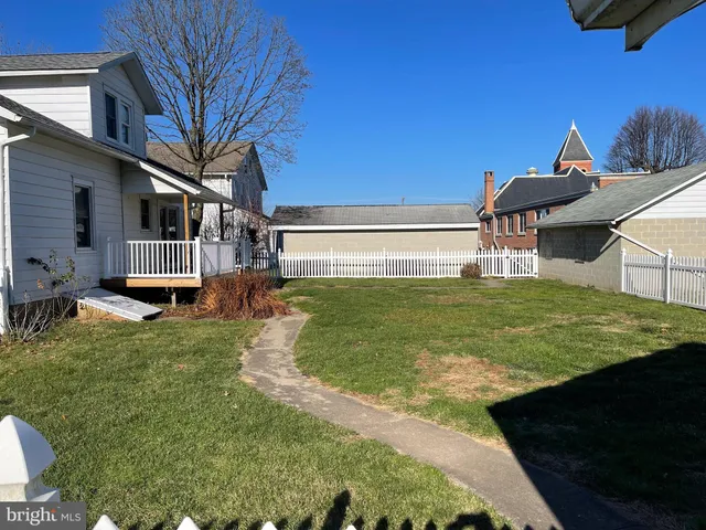 a view of a house with backyard and a tree
