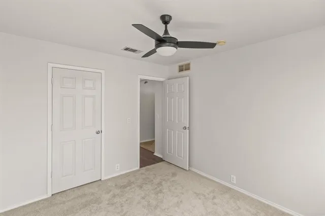 a view of a hallway with a ceiling fan