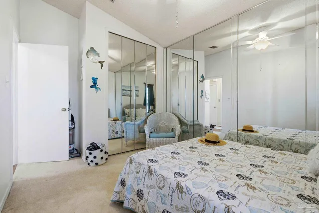 a bedroom with a bed mirror and chandelier