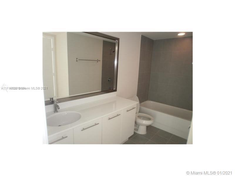 92 Southwest 3rd Street, Unit 3802 Miami, FL 33130 - Photo 6 of 10 a bathroom with a granite countertop sink a toilet and a large mirror