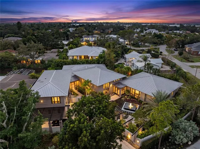 an aerial view of residential houses with outdoor space and trees