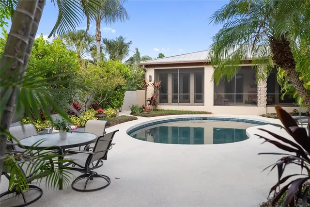 a view of backyard with swimming pool and table and chairs
