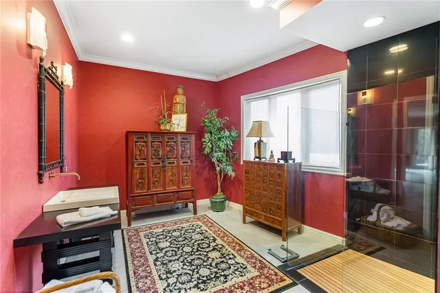 a front view of a house with lots of flowers and trees