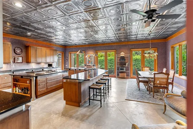 a open kitchen with stainless steel appliances granite countertop a stove a sink dishwasher and couches with wooden floor