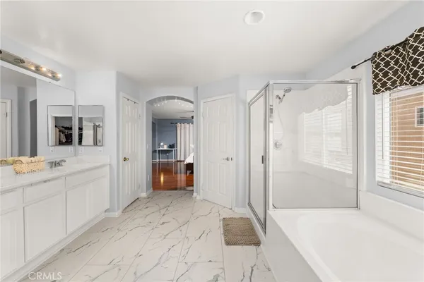 a large white bathroom with a sink and mirror