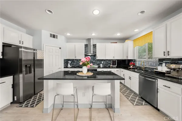 a kitchen with stainless steel appliances granite countertop a stove a sink a microwave a refrigerator and cabinets