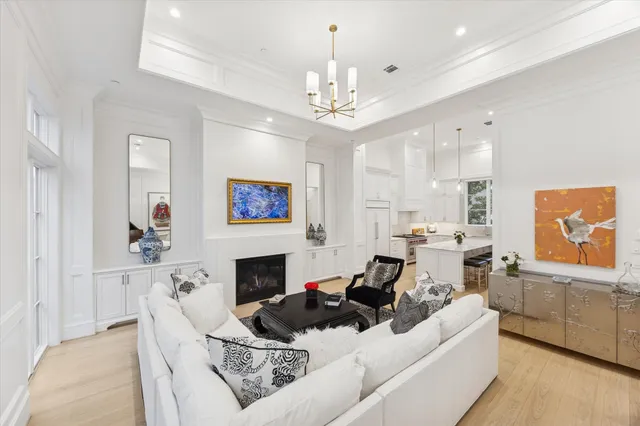 a living room with furniture a fireplace and a chandelier