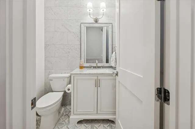 a bathroom with a toilet a sink and mirror