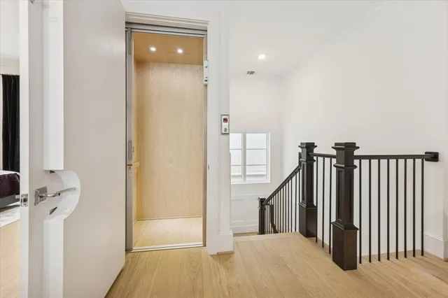 a view of a hallway with wooden floor and staircase