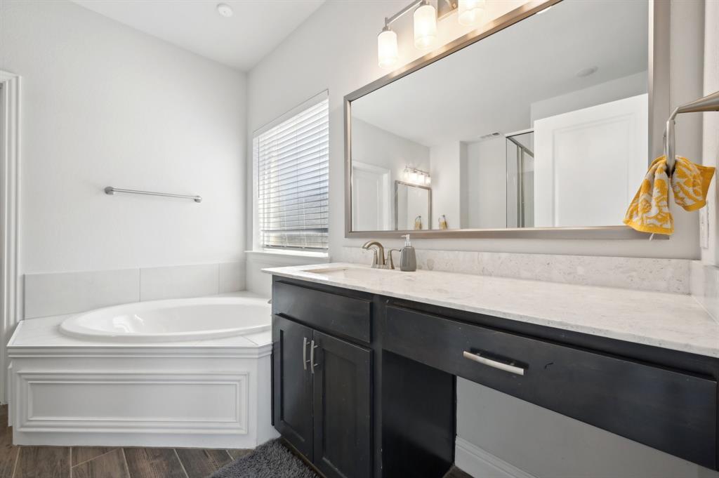 2172 Poppyvine Road Frisco, TX 75033 - Photo 23 of 40 Bathroom featuring a garden tub, vanity, dark wood finished floors, and a stall shower