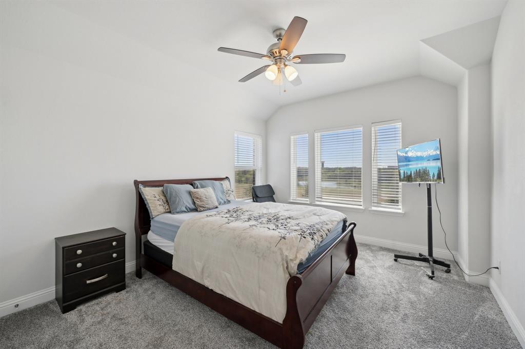 2172 Poppyvine Road Frisco, TX 75033 - Photo 27 of 40 Carpeted bedroom with lofted ceiling and a ceiling fan