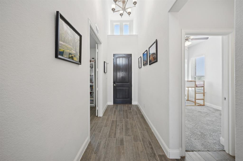 2172 Poppyvine Road Frisco, TX 75033 - Photo 7 of 40 Hallway with wood tiled floors, a high ceiling, and suspended lighting