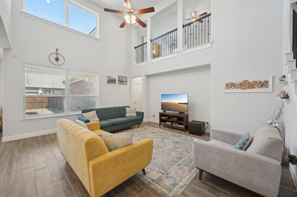 2172 Poppyvine Road Frisco, TX 75033 - Photo 8 of 40 Living room featuring wood tiled floors, ceiling fan, and a high ceiling
