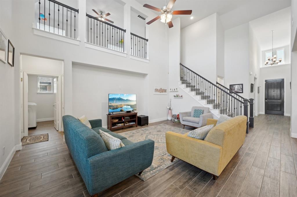 2172 Poppyvine Road Frisco, TX 75033 - Photo 9 of 40 Living area featuring a high ceiling, wood tiled floors, a ceiling fan, and a chandelier