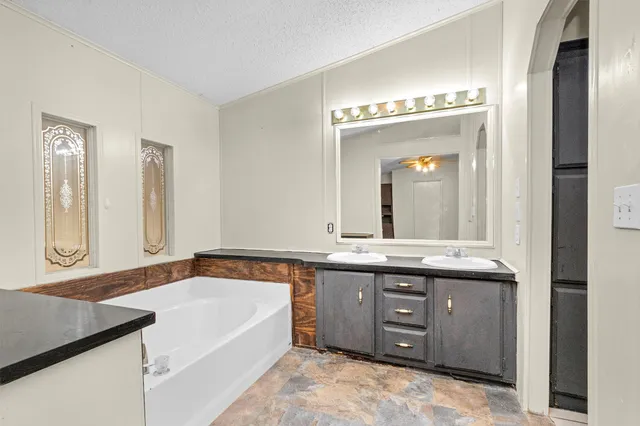 a spacious bathroom with a granite countertop sink and a mirror