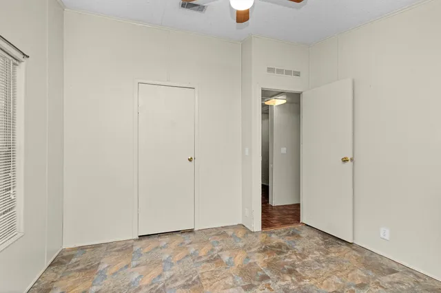 a view of an empty room with closet and a window