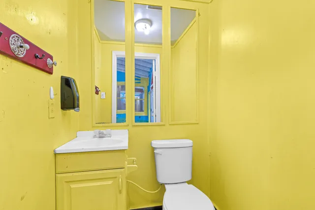 a bathroom with a toilet sink and mirror