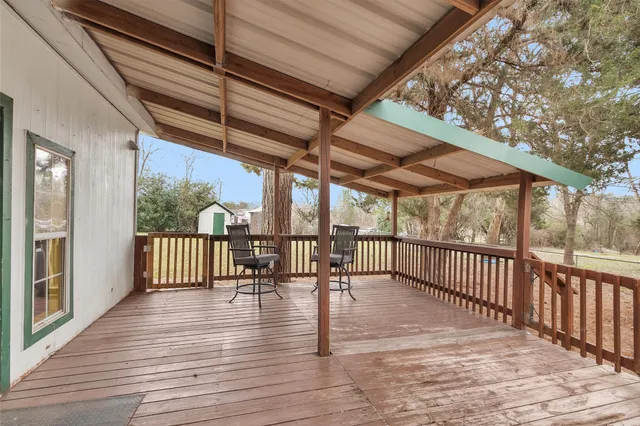 a view of a patio with wooden floor table and chairs