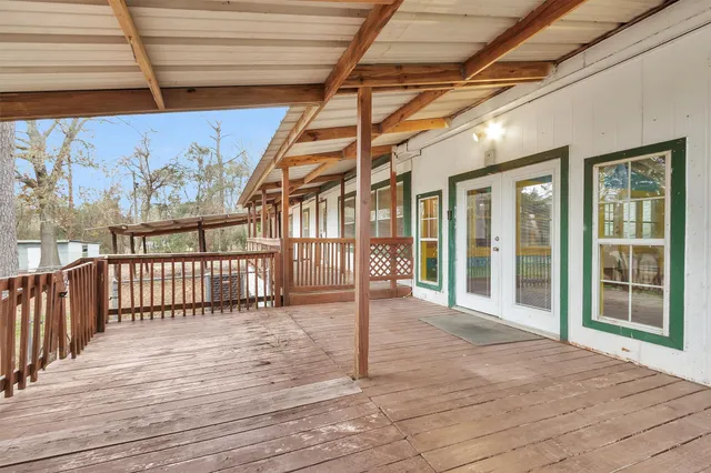 a view of a porch with wooden floor and fence