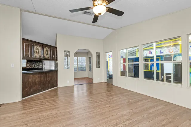 a view of an empty room with window and wooden floor