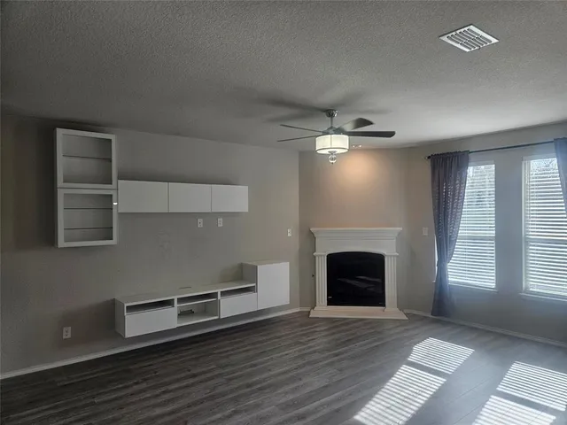 an empty room with windows and fireplace