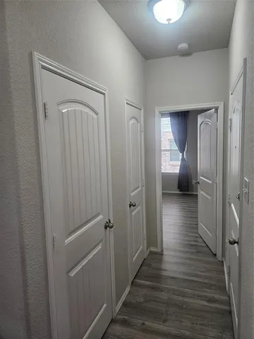 a view of a hallway with wooden floor