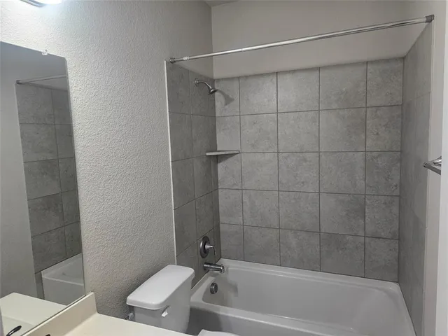 a white bath tub sitting next to a toilet