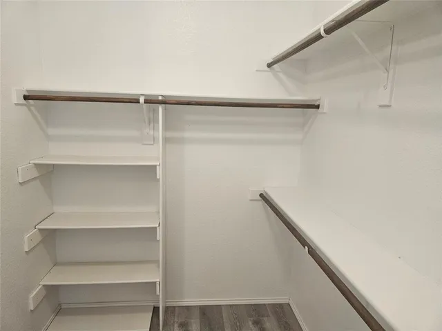 a view of walk in closet with empty racks