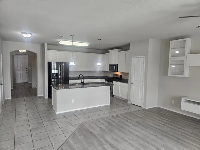 a large kitchen with stainless steel appliances kitchen island a refrigerator sink and cabinets